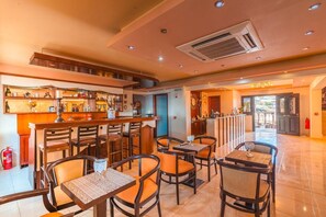 Ein Restaurant mit Barbereich, verschiedenen Sitzmöglichkeiten und einem sichtbaren Feuerlöscher.