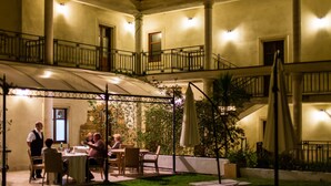Un patio con comedor, asientos al aire libre y una escalera que lleva a un nivel superior.
