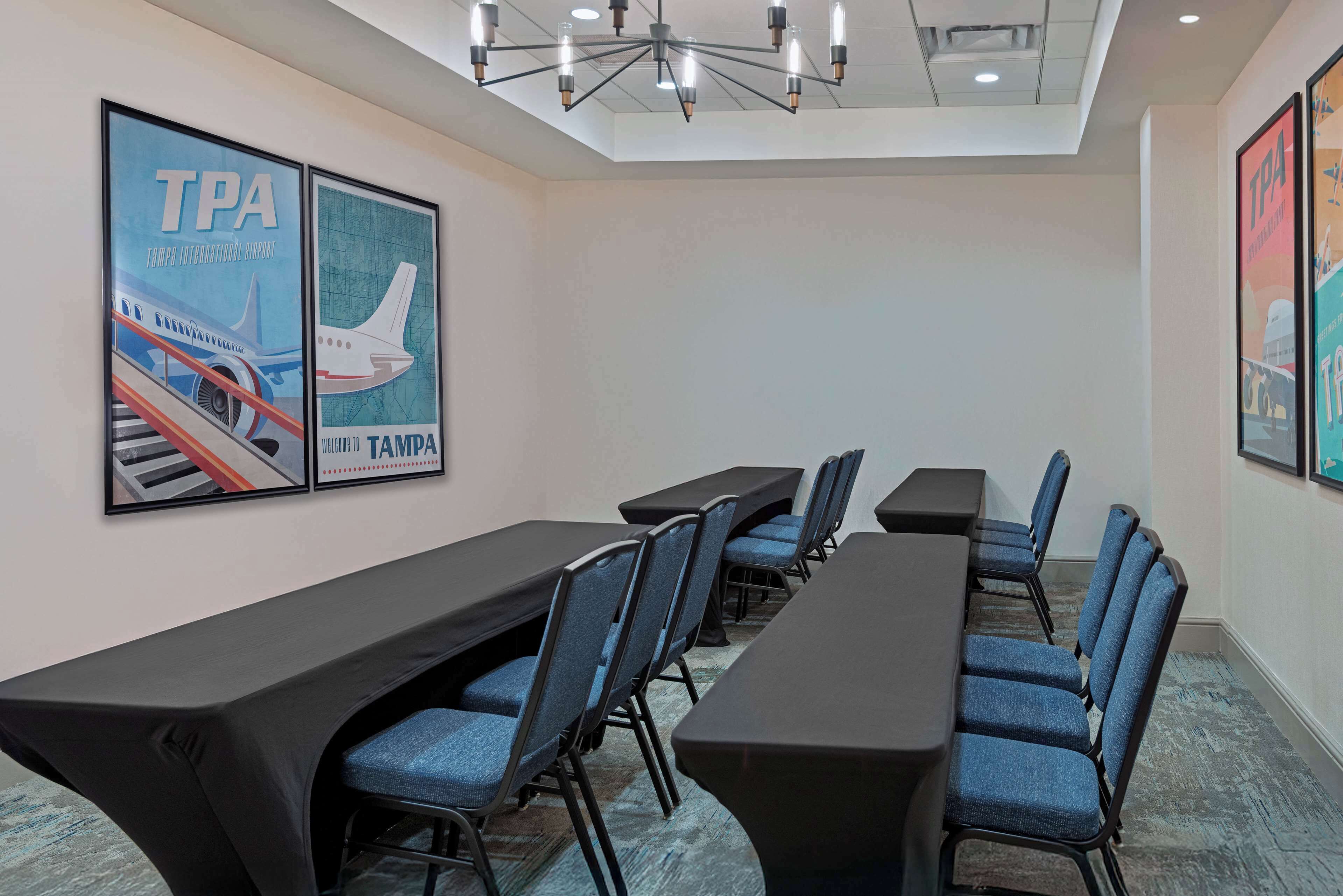 A conference room with a long table, blue chairs, and TPA posters on the wall.
