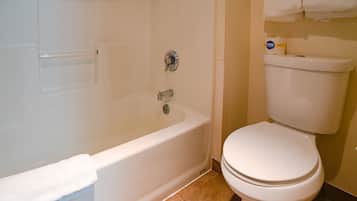 A bathroom with a bathtub, toilet, and a towel rack.