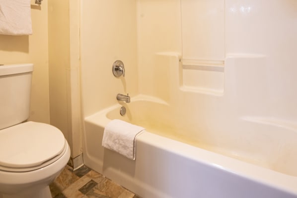 Un baño con inodoro, bañera y ducha.