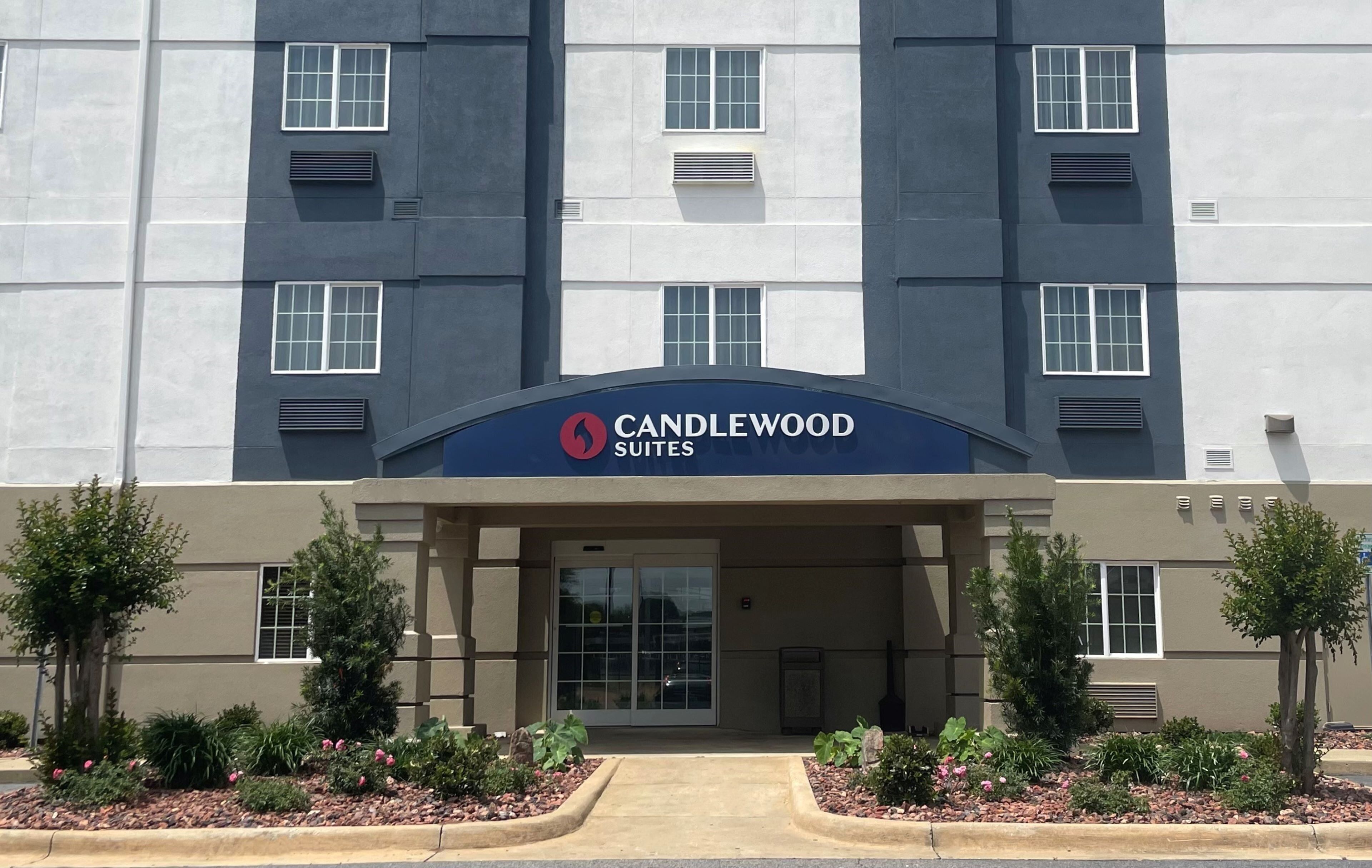 Una entrada de hotel moderna con un letrero que dice "CANDLEWOOD SUITES".