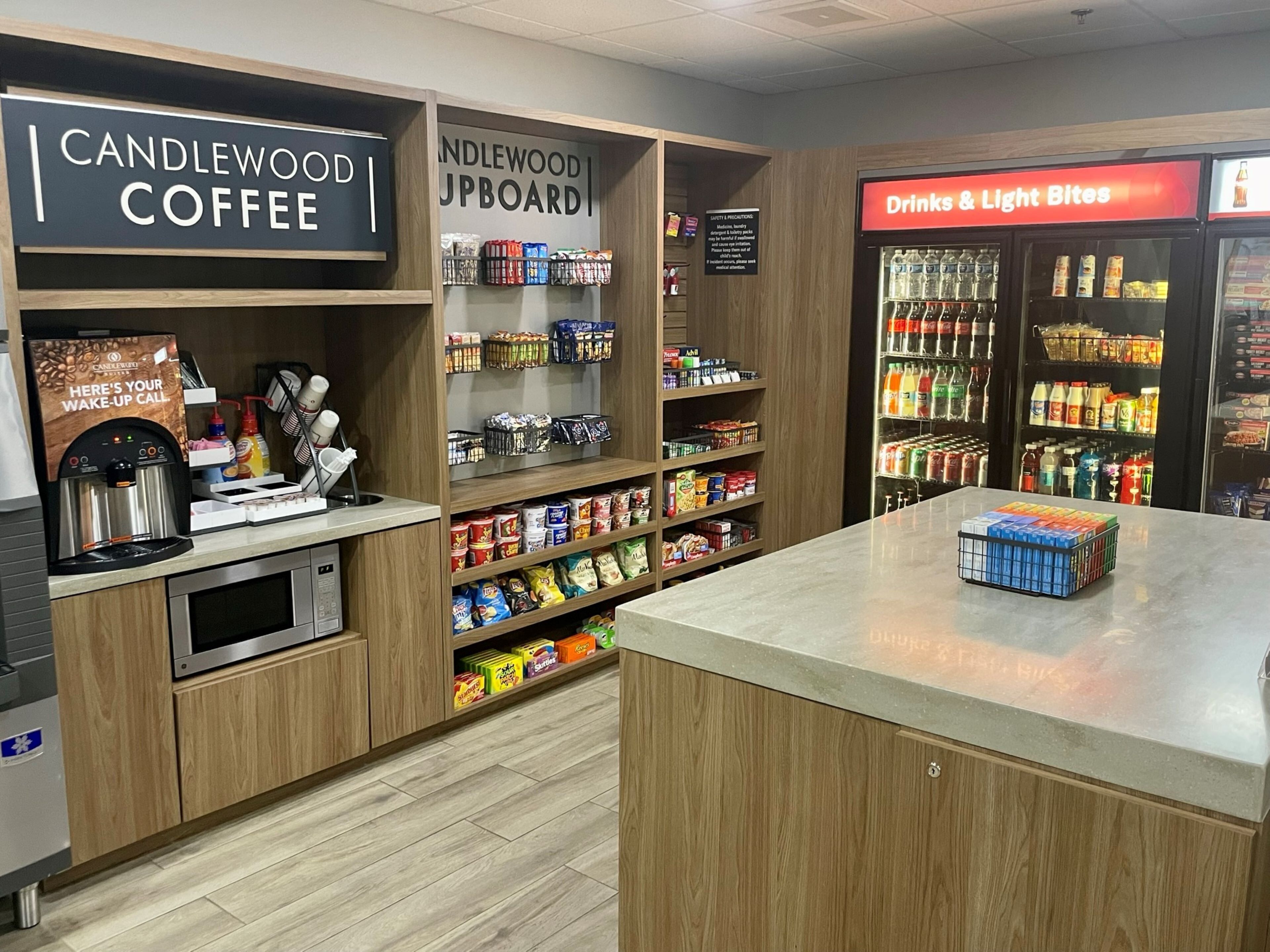 A coffee shop with a coffee machine, shelves of snacks, and a drinks & light bites fridge.