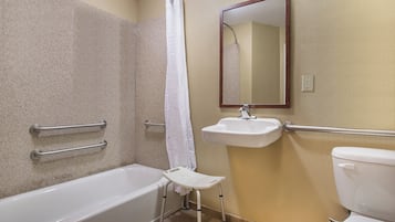 A bathroom with a bathtub, a sink, a toilet, a shower curtain, and a mirror.