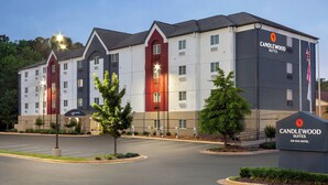 A multi-story hotel with a modern design, featuring a prominent logo on the facade. - Candlewood Suites Tuscaloosa by IHG (Tuscaloosa)