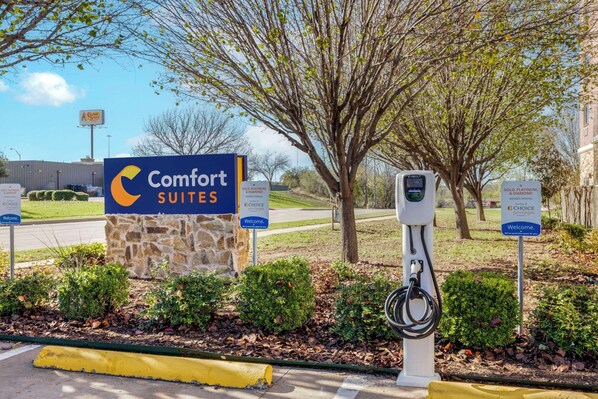 Señal de Comfort Suites con base de piedra y fondo azul.