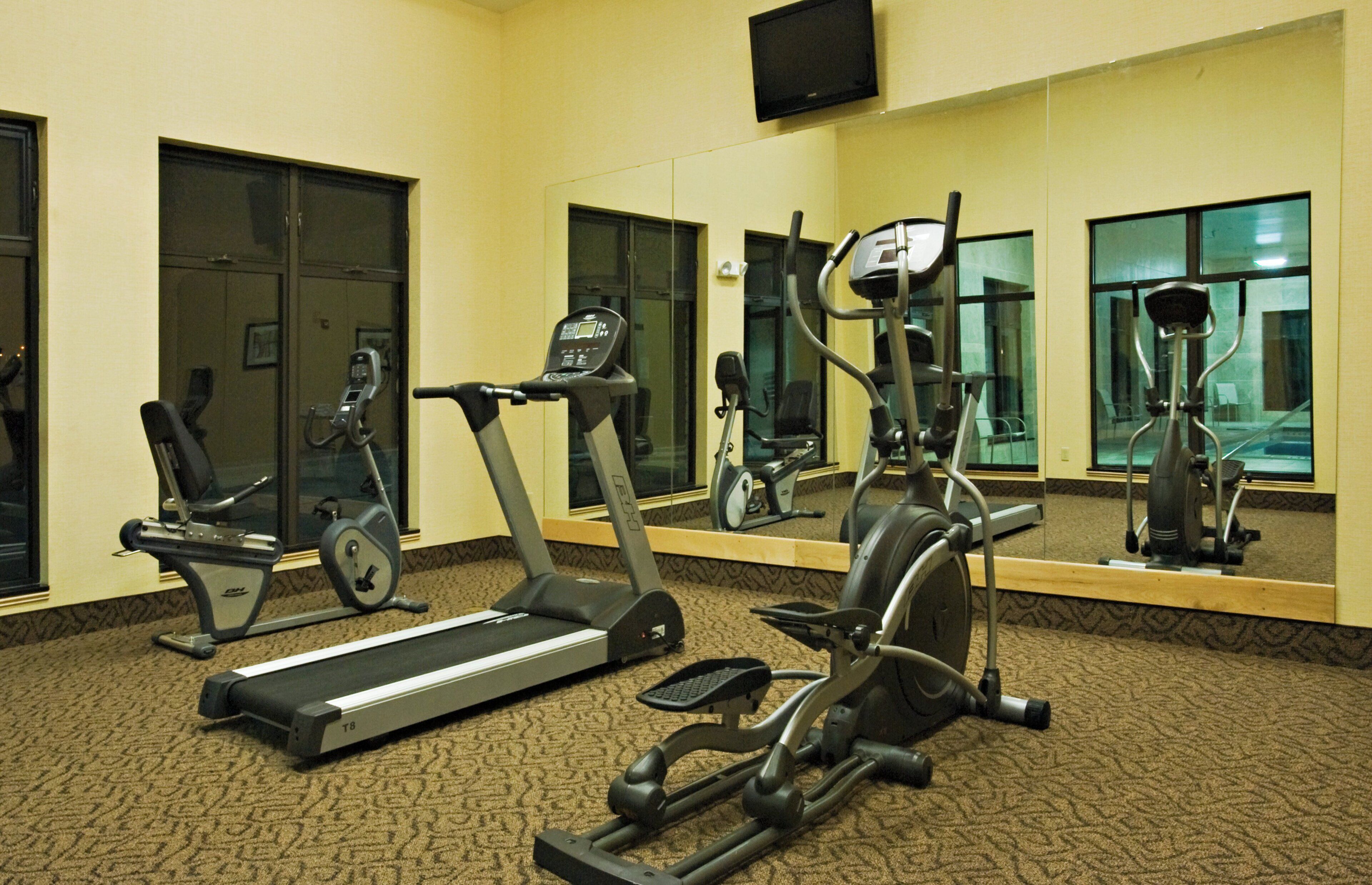 A gym with treadmills, stationary bikes, and elliptical machines.
