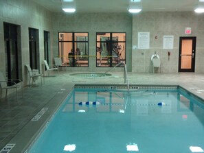 An indoor swimming pool with clear lane markings, a diving board, and a lifeguard chair. - Holiday Inn Express & Suites Borger by IHG (Borger)