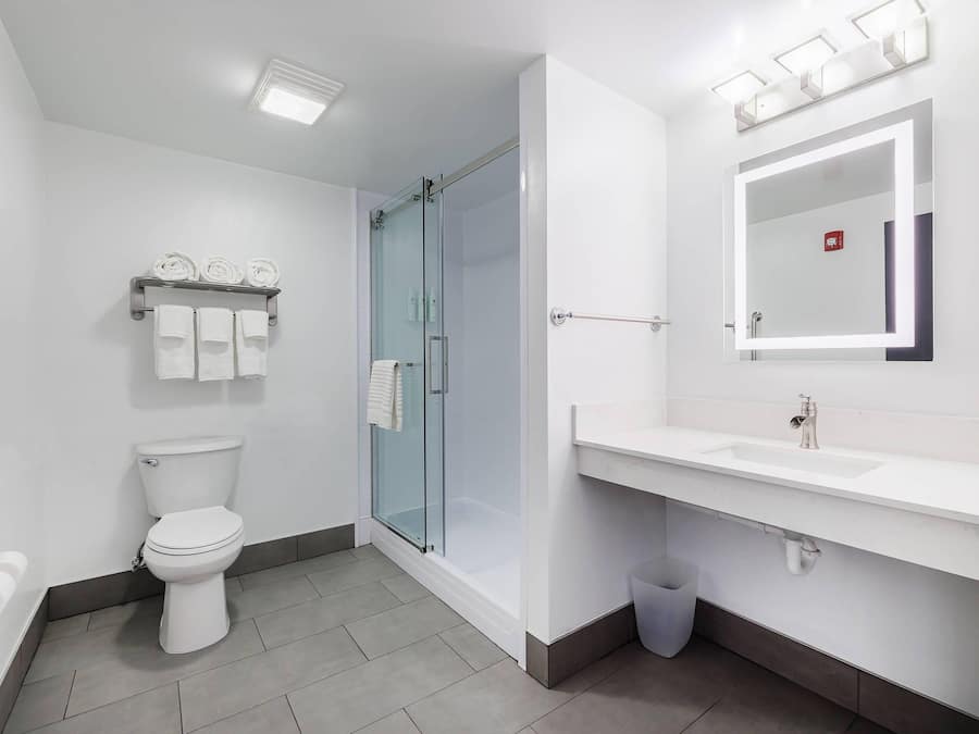 A modern bathroom with a toilet, shower, and sink.