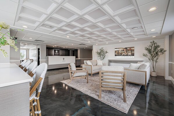 A modern interior with a kitchen, seating area, and a large ceiling with recessed lighting.