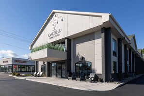 A hotel with a modern design, a covered entrance, and outdoor seating. - Oakfield Hotel & Suites, Ascend Collection, Rochester-Pittsford NY (Rochester)