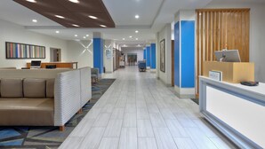 A modern hotel lobby with a reception desk, seating area, and a hallway leading to other rooms. - Holiday Inn Express Amarillo South by IHG (Amarillo)