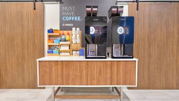 A coffee station with a sign that reads "MUST HAVE COFFEE." It includes a coffee machine, a water dispenser, and various coffee-related items.