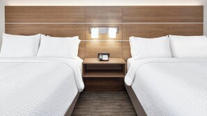A hotel room with two beds, a wooden headboard, a bedside table with a phone, and a wall-mounted light fixture. - Holiday Inn Express Amarillo South by IHG (Amarillo)