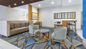 A modern hotel lobby with a sofa, chairs, a small table, and a bar area. - Holiday Inn Express Amarillo South by IHG (Amarillo)
