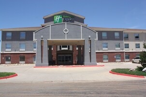 Edificio de Holiday Inn Express con fachada de ladrillo, ventanas amplias y entrada cubierta.