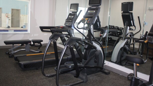 A gym with treadmills, ellipticals, and a mirrored wall. - Holiday Inn Express Hotel & Suites Shamrock North by IHG (Shamrock)