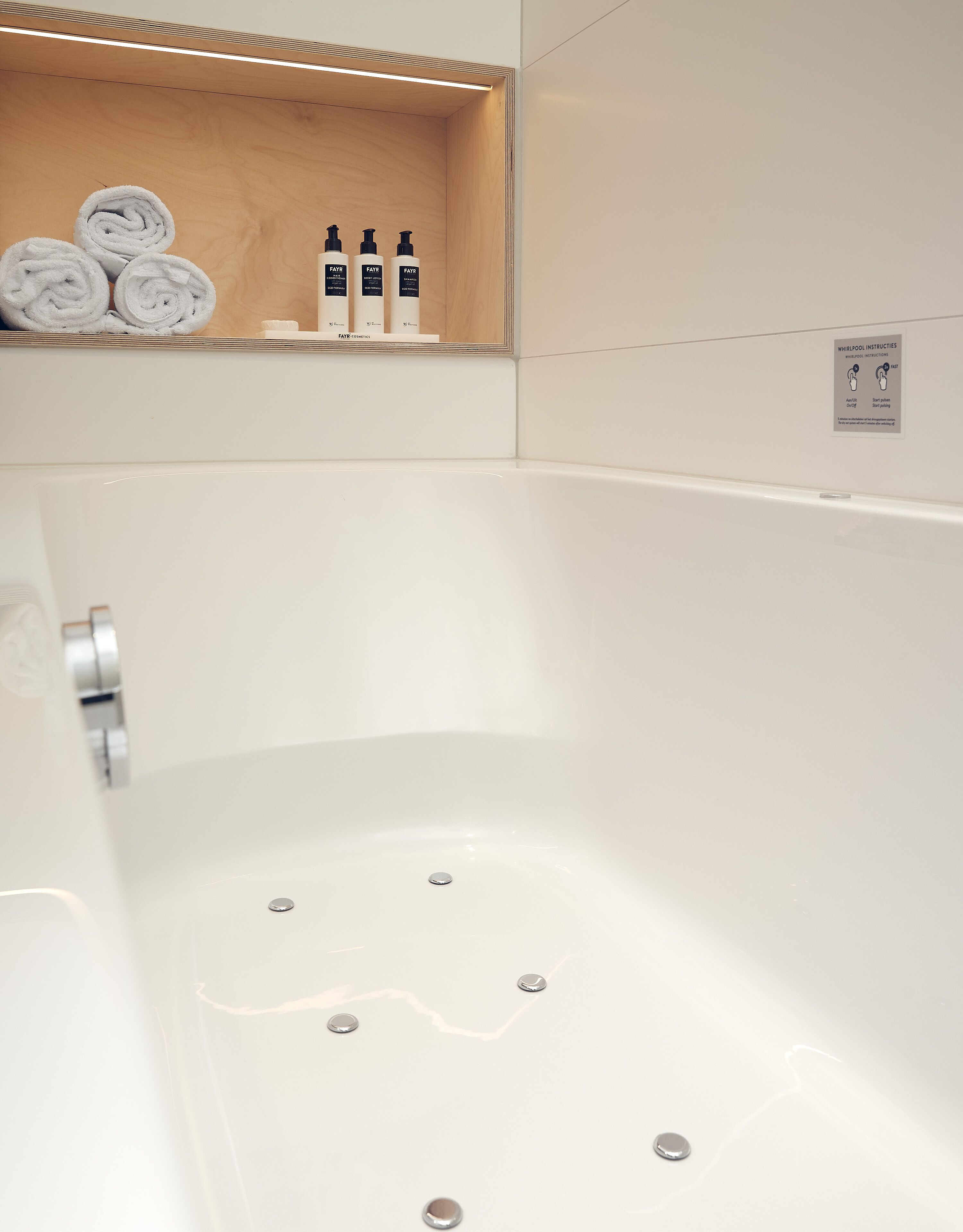 Un baño moderno con un estante de madera que sostiene toallas y artículos de aseo.