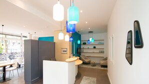 A modern kitchen with a central island, pendant lights, and a view into the dining area.