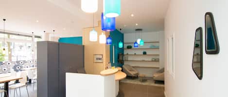 A modern kitchen with a central island, pendant lights, and a view into the dining area.
