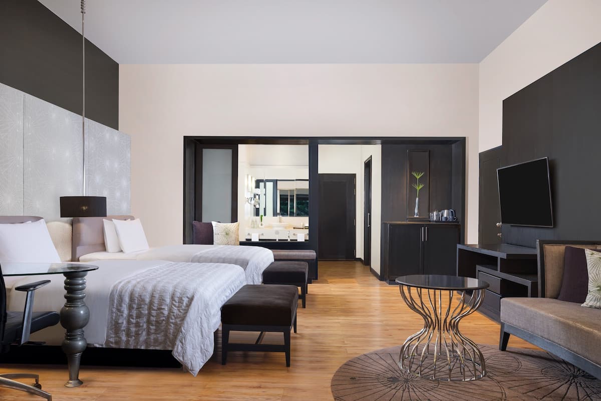 Une chambre d’hôtel moderne dotée d’un grand lit, d’un canapé, d’une télévision et d’un coin repas.