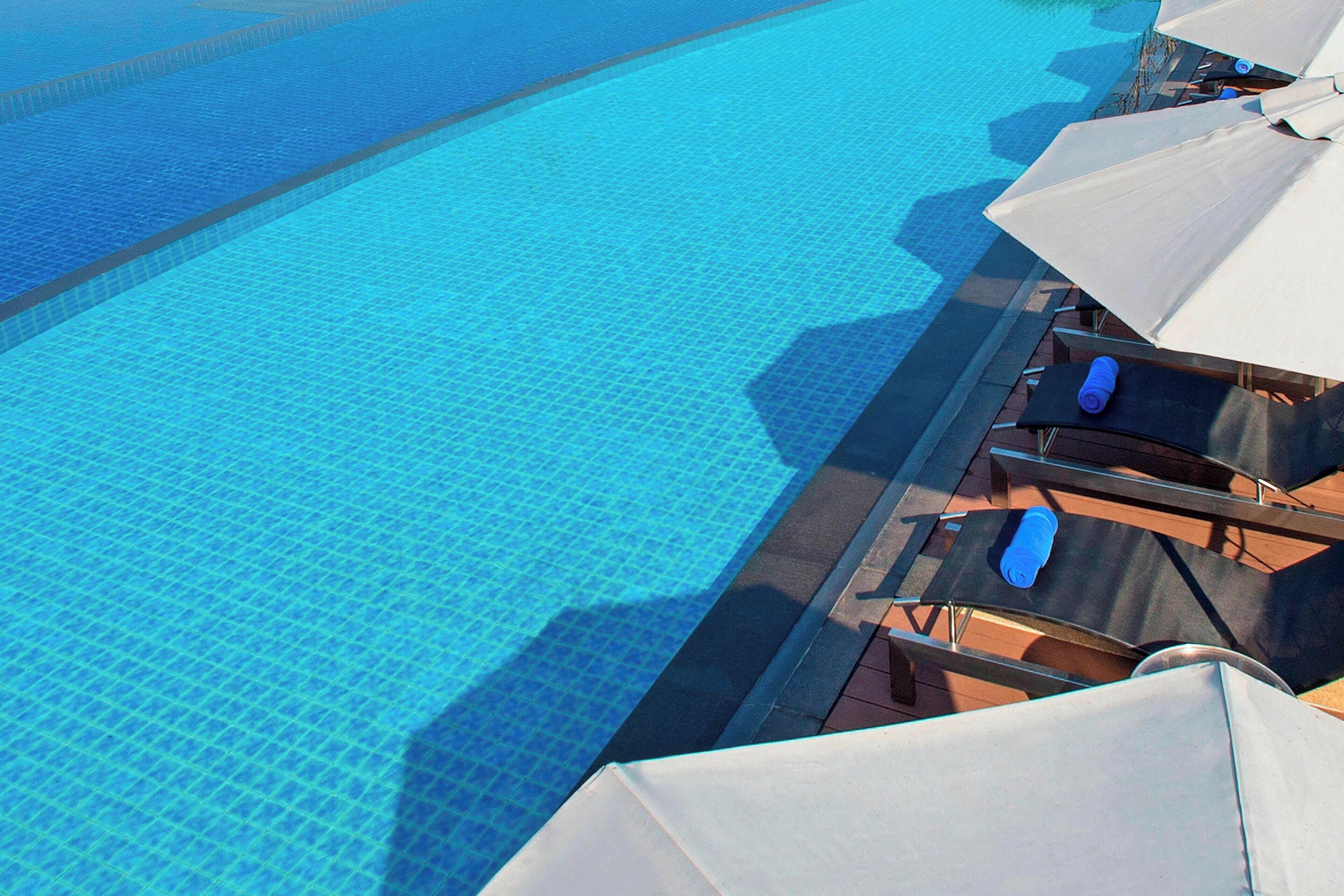A poolside area with lounge chairs and umbrellas.