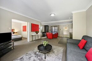 Deluxe One Bedroom Spa Apartment | Living area | Flat-screen TV - Platinum International (Harristown)