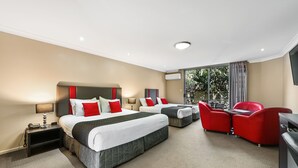 Una habitación de hotel con dos camas, un escritorio, una silla y un televisor.
