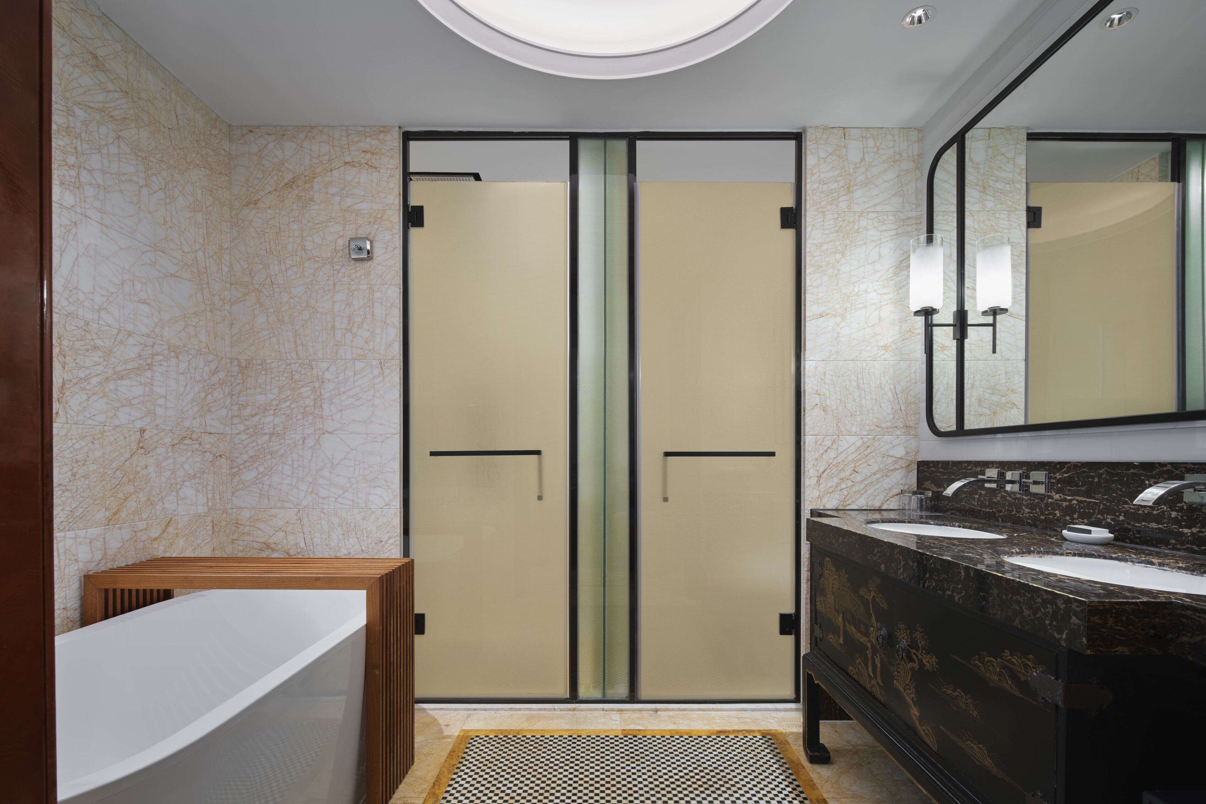 Un baño moderno con bañera, puertas dobles, un tocador con dos lavamanos y un espejo grande.
