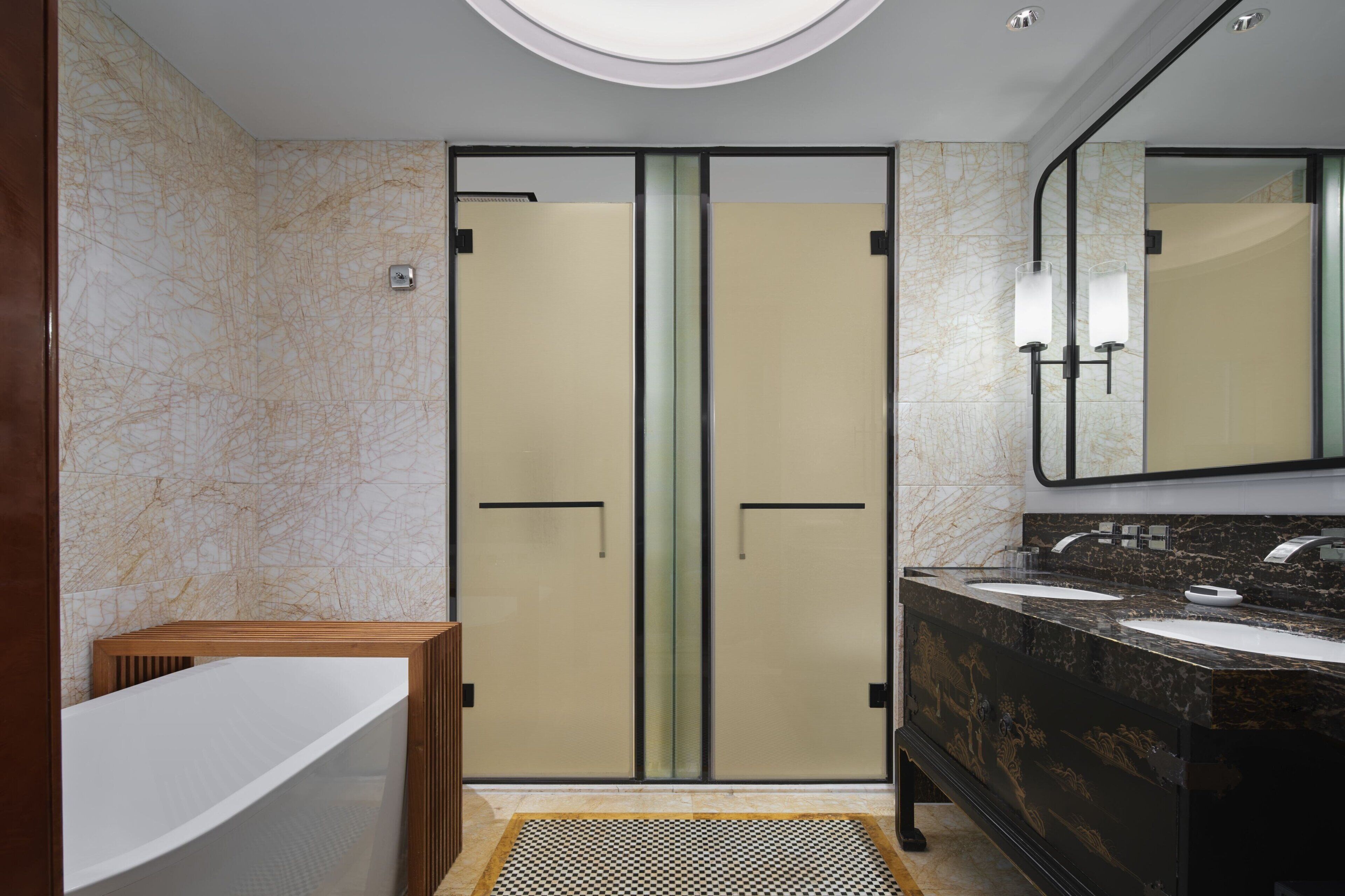 Une salle de bain moderne avec un meuble-lavabo double, un grand miroir et une zone de douche séparée.