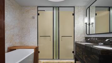 Une salle de bain moderne avec un meuble-lavabo double, un grand miroir et une zone de douche séparée.