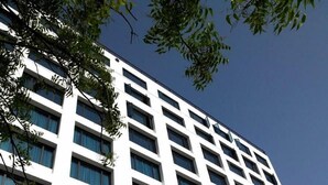 A modern high-rise building with a white facade and multiple windows. - Hotel Paradise (Jaipur)