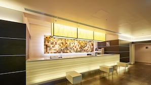 A reception area with a counter, seating, and a decorative wall. - Sotetsu Fresa Inn Higashi Shinjuku (Tokyo)