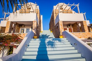 Stunning staircase leading up to a building with a unique architectural style, featuring a combination of white and stone elements.