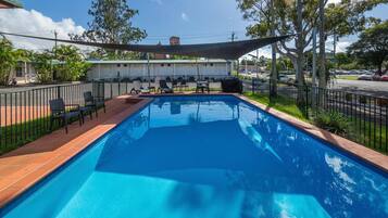 Alberca al aire libre y camastros