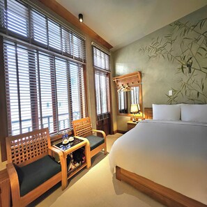 A hotel room with a large bed, wooden furniture, and large windows with blinds. - Victory Hotel Hue (Hue)