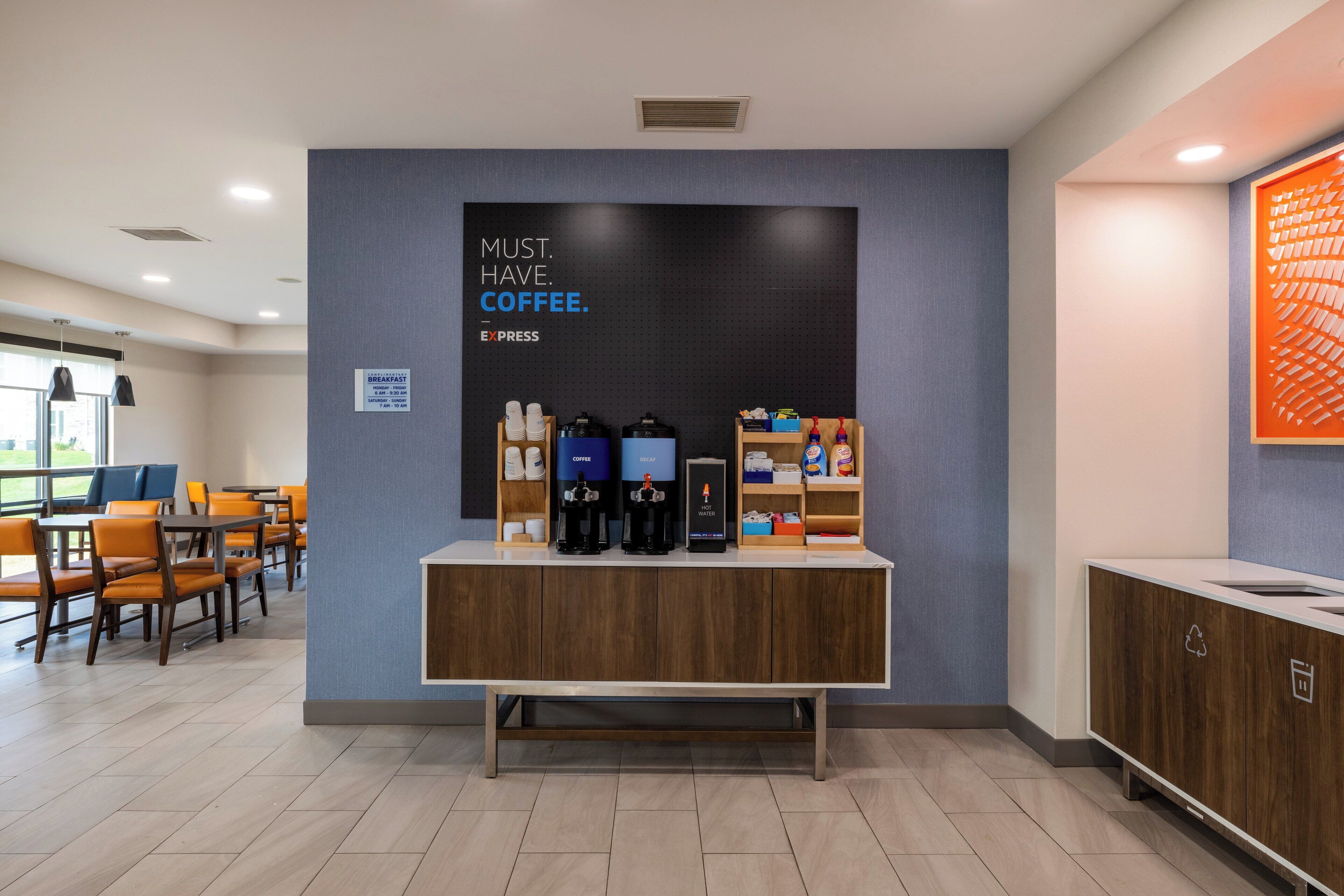 A coffee station with a sign that reads "MUST. HAVE. COFFEE." and a coffee machine.