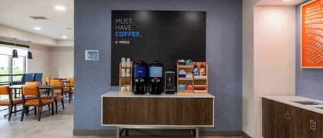 A coffee station with a sign that reads "MUST. HAVE. COFFEE." and a coffee machine.