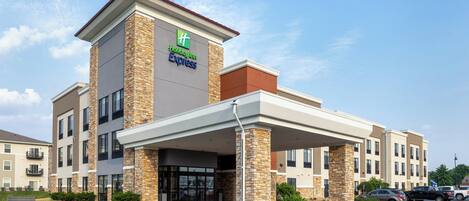 A Holiday Inn Express building with a covered entrance, multiple floors, and a parking lot.