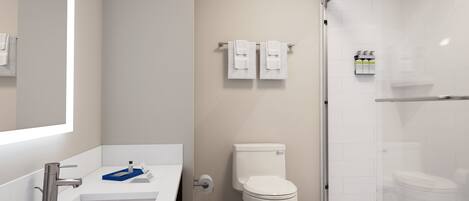 A modern bathroom with a white sink, toilet, and shower.