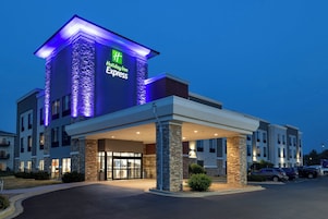 Edificio de Holiday Inn Express, con fachada de piedra y señalización iluminada.
