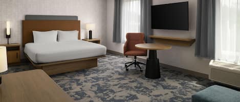 A hotel room with a bed, a desk, a chair, a TV, and a window with curtains.