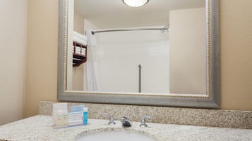 Un bagno con uno specchio grande, un lavandino e una doccia.