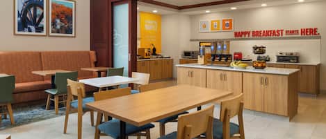 A modern cafe with wooden furniture, a breakfast bar, and a sign that reads 'HAPPY BREAKFAST STARTS HERE.'