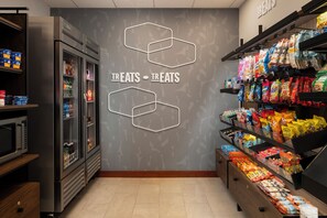 A grocery store interior with a refrigerated section on the left and snack shelves on the right. - Hampton Inn & Suites Mystic (Mystic)
