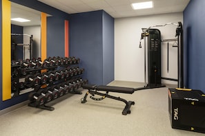 A gym with weightlifting equipment, including dumbbells and a bench. - Hampton Inn & Suites Mystic (Mystic)