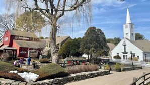 A rural village scene with a church, a red building labeled 'KITCH', and a stone wall. - Hampton Inn & Suites Mystic (Mystic)