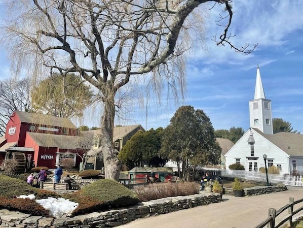 A rural village scene with a church, a red building labeled 'KITCH', and a stone wall.