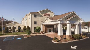 A Hampton Inn & Suites building with a covered entrance, handicap-accessible parking, and a clear sky. - Hampton Inn & Suites Mystic (Mystic)