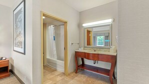 A bathroom with a wooden vanity, a large mirror, and a shower area. - Hampton Inn & Suites Mystic (Mystic)
